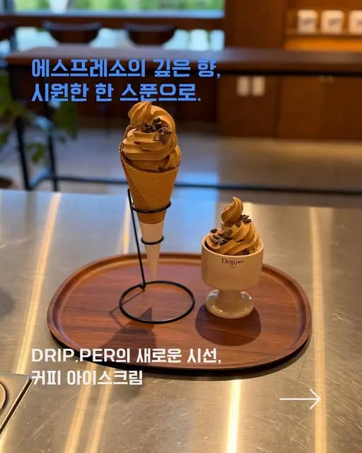 나무 트레이에 올린 커피 아이스크림 두 가지. 왼쪽은 콘에 담긴 소프트아이스크림, 오른쪽은 커피드립퍼 로고가 새겨진 컵에 담긴 아이스크림이며 위에 커피콩 토핑이 올려져 있다.
